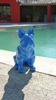 a blue figurine sitting next to a swimming pool at Le mas de la diligence in Mirabeau