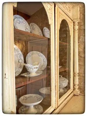 a glass cabinet with plates and bowls in it at La Providence in Apt