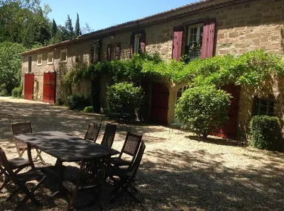 a table and chairs in front of a building at La Jacquemarie in Monteux