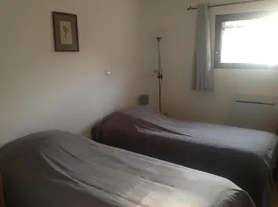 a bedroom with two beds and a window at La Jacquemarie in Monteux