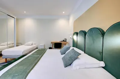 a bedroom with two beds with green headboards at Urban Style Hotel Blason du Ventoux in Carpentras