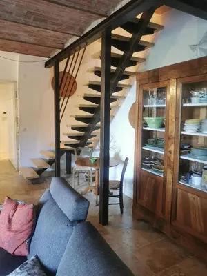 a living room with a blue couch and stairs at Le Provençal Duplex piscine jardin le Luberon in Puyvert