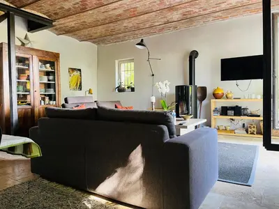 a living room with a couch and a tv at Le Provençal Duplex piscine jardin le Luberon in Puyvert
