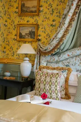 a bedroom with a bed with a book and a lamp at Villa Gallici Hôtel & Spa in Aix-en-Provence