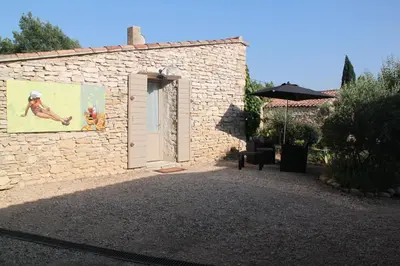 a stone building with a door with a painting on it at Le Hameau Fleur de Pierres , Chambre , Gite et Table d'Hôtes in Murs