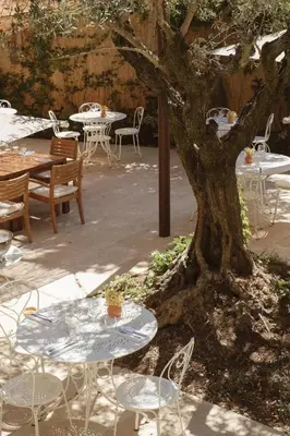 a restaurant with tables and chairs and umbrellas at Le Moulin, Lourmarin, a Beaumier Hotel in Lourmarin