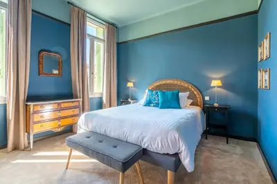 a blue bedroom with a bed with a blue wall at La Maison d'été in Salon-de-Provence