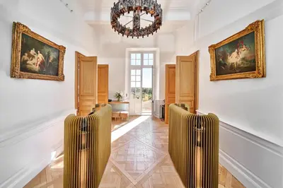 a room with a chandelier and two paintings on the wall at Château de la Gaude in Aix-en-Provence