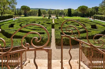 a garden with a maze of hedges and benches at Château de la Gaude in Aix-en-Provence