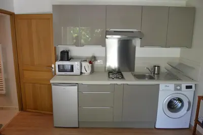 a kitchen with a microwave and a stove top oven at Charmante maisonnette indépendante avec piscine à Goult in Goult