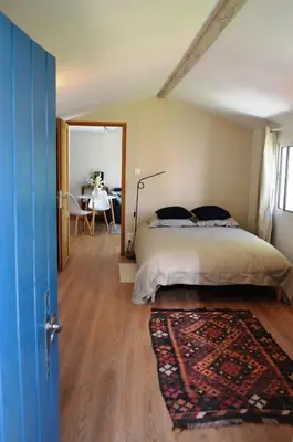 a bedroom with a bed and a table in a room at Charmante maisonnette indépendante avec piscine à Goult in Goult