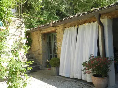 a house with a white curtain on the side of it at Les Acanthes in Lauris
