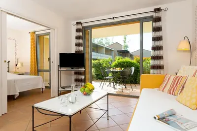 a living room with a couch and a table at Madame Vacances Résidence Provence Country Club in Saumane-de-Vaucluse