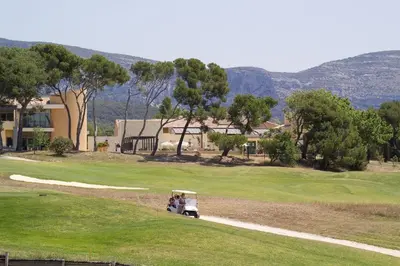 two people in a golf cart on a golf course at Madame Vacances Résidence Provence Country Club in Saumane-de-Vaucluse