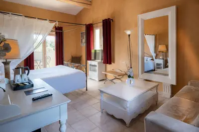 a bedroom with a bed and a living room at Mas De La Senancole & Spa in Gordes