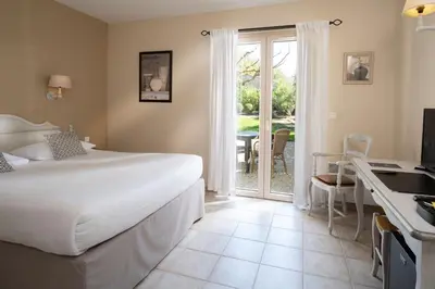 a bedroom with a bed and a sliding glass door at Mas De La Senancole & Spa in Gordes