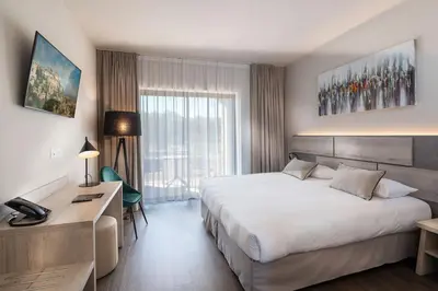 a hotel room with a bed and a desk at Mas De La Senancole & Spa in Gordes