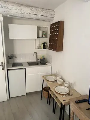 a kitchen with a table with plates on it at L'Escapade Aixoise hyper centre historique studios free netfilx wifi romantics apartments historic center in Aix-en-Provence