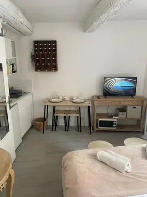 a living room with a table and a television at L'Escapade Aixoise hyper centre historique studios free netfilx wifi romantics apartments historic center in Aix-en-Provence