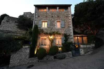 a stone house with a gate in front of it at Le Bonheur in Gordes