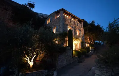 an old stone building with lights on it at night at Le Bonheur in Gordes