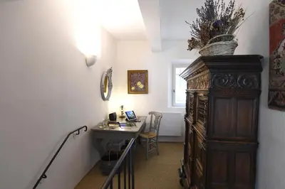 a hallway with a desk and a large wooden cabinet at Le Bonheur in Gordes