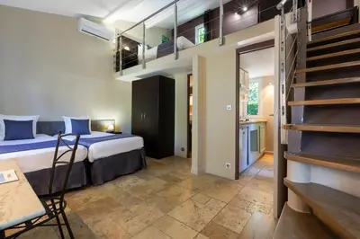 a bedroom with a bunk bed and a staircase at SOWELL HOTELS Domaine de la Petite Isle in LʼIsle-sur-la-Sorgue