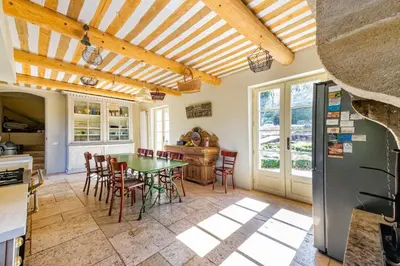 a kitchen and dining room with a table and chairs at Villa spacieuse avec jardin à Saignon in Saignon