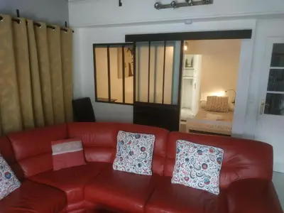 a red couch in a living room with pillows on it at La Campanette en Luberon -Piscine privée in Cheval-Blanc