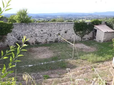 an old stone wall with a yard at Gîte du Mas Saint-Victor in Bonnieux