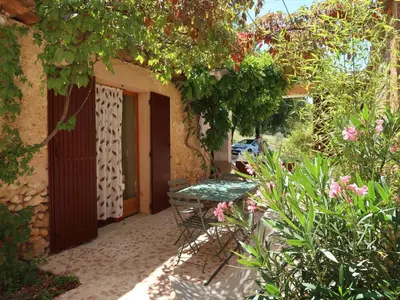 a patio with a table and a bench in a garden at Holiday Home Les Huppes by Interhome in Saint-Saturnin-les-Apt