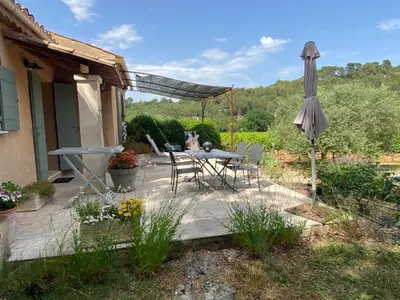 a patio with an umbrella and a table and chairs at La Manaude in Ménerbes