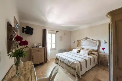a bedroom with a bed and a vase of flowers at Le Mas Silvestre in Saint-Saturnin-les-Apt
