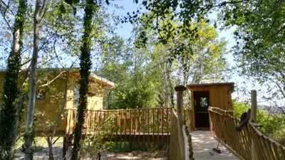 a cabin in the woods with a wooden fence at LA CABANE PERCHEE in Villelaure