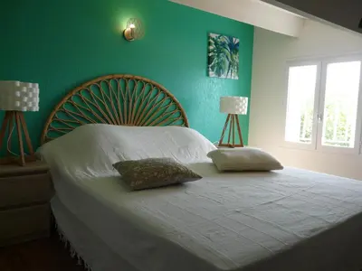 a green bedroom with a bed with two pillows on it at Bleu de l'Isle in LʼIsle-sur-la-Sorgue