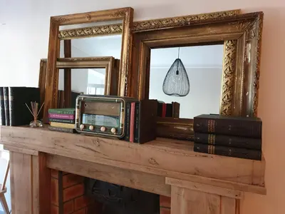 an old television and books on a mantel with a mirror at Le Clos Marceau in Bédoin