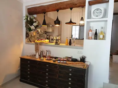 a kitchen with a dresser and a clock on the wall at Le Clos Marceau in Bédoin