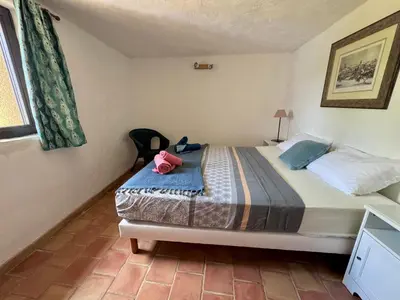 a bedroom with a bed with a pink hat on it at Bastide du Buou in Puyvert