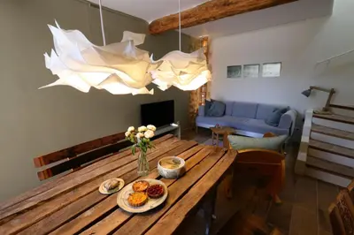 a living room with a wooden table with food on it at Sous le Château in Rustrel