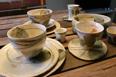 a group of cups sitting on a wooden table at Sous le Château in Rustrel