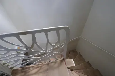 a metal bed in a room with a staircase at Sous le Château in Rustrel