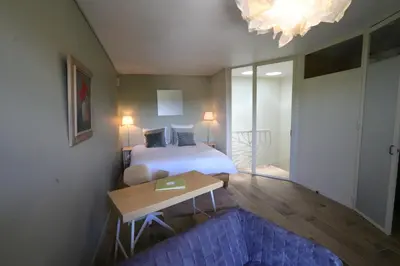 a bedroom with a bed and a table and a couch at Sous le Château in Rustrel