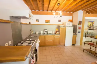 a kitchen with a stove and a white refrigerator at Domaine en Provence Gîte la Ferrandiere in Carpentras
