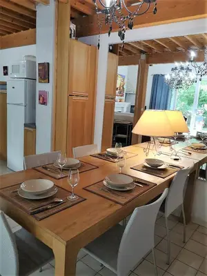 a wooden table with plates and wine glasses on it at Domaine en Provence Gîte la Ferrandiere in Carpentras