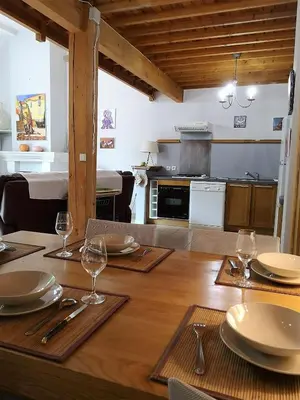a wooden table with plates and wine glasses on it at Domaine en Provence Gîte la Ferrandiere in Carpentras