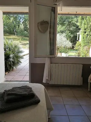 a bedroom with a bed with a mirror and a window at Domaine en Provence Gîte la Ferrandiere in Carpentras