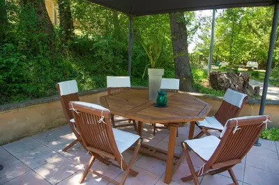 a wooden table and chairs on a patio at Domaine en Provence Gîte la Ferrandiere in Carpentras