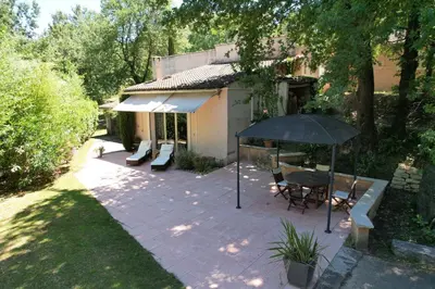 a patio with an umbrella and a table and chairs at Domaine en Provence Gîte la Ferrandiere in Carpentras