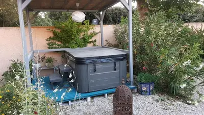 a garbage can sitting under a pergola in a garden at le Mas d'Hubert in LʼIsle-sur-la-Sorgue