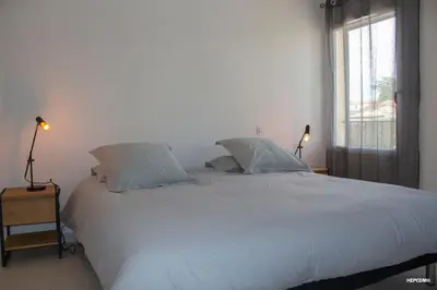 a bedroom with a large white bed with two pillows at BASTIDE 9 in La Fare-les-Oliviers